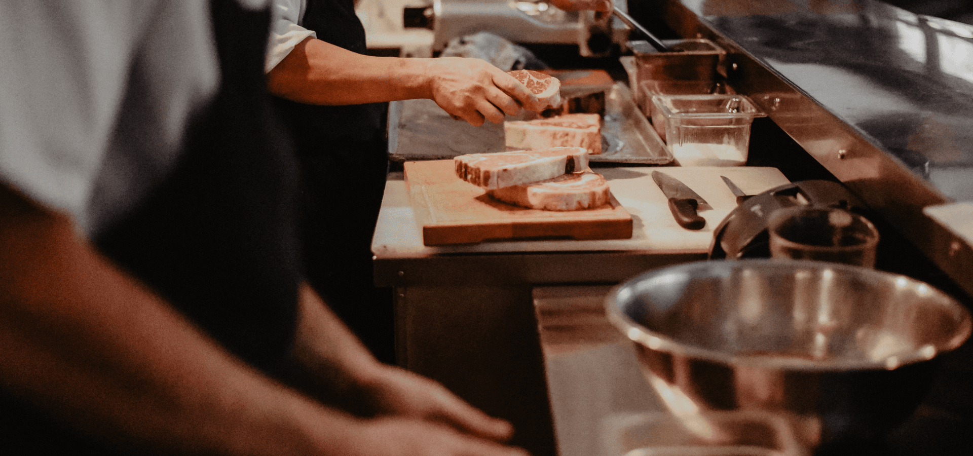 Close up of a kitchen line, preparing cuts of steak. Photo courtesy of BHC.