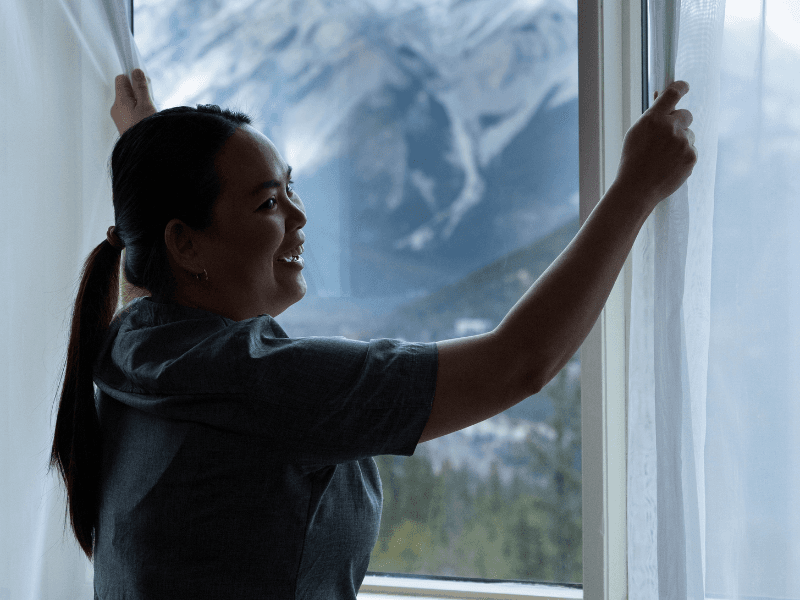 Housekeeping team member opening curtains